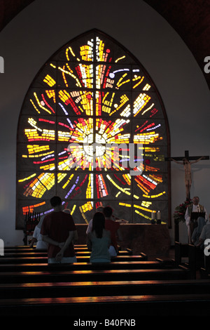 Mass at the Templo ecumenico El Salvador in Playa del Ingles with the sun streaming through the stained glass window Stock Photo