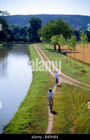 Woman and boy bicycling along the Canal du Nivernais, Burgandy Region ...