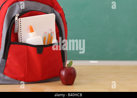 School education still life backpack full of school supplies and red apple Stock Photo