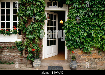 Ivy covered wall and front door to a country farm house, Normandy Region, France Stock Photo