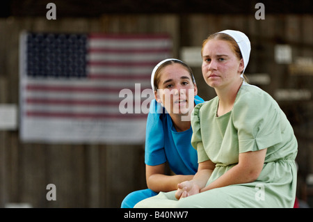 Mennonite Teenage Girls Talking at Heritage Festival with American Flag Behind Lanesville Indiana Stock Photo