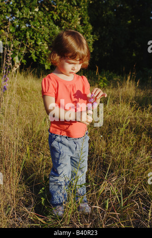 Girl standing in field of tall grass Stock Photo - Alamy