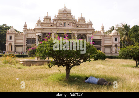 A man sleeps in the grounds of the Jagan Mohan Palace in Mysore, India. Stock Photo