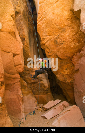 USA, Utah.  A female canyoneer rappeling in Chute Canyon on the San Rafael Swell.  (MR) Stock Photo