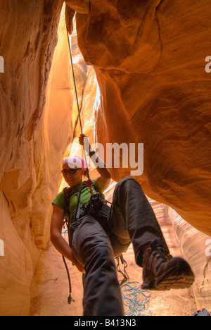 USA, Utah.  A female canyoneer rappeling in Chute Canyon on the San Rafael Swell.  (MR) Stock Photo