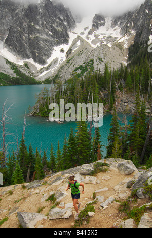 Washington, Cascade Mountains, Leavenworth.  A female trail runner above Colchuck Lake.  (MR) Stock Photo