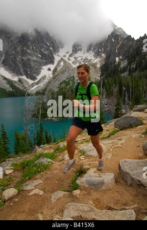 Washington, Cascade Mountains, Leavenworth.  A female trail runner above Colchuck Lake.  (MR) Stock Photo