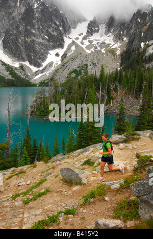 Washington, Cascade Mountains, Leavenworth.  A female trail runner above Colchuck Lake.  (MR) Stock Photo