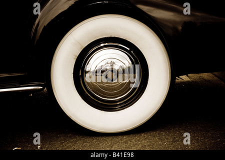 Classic Cadillac wheel with white wall tyres and polished hub caps. Stock Photo