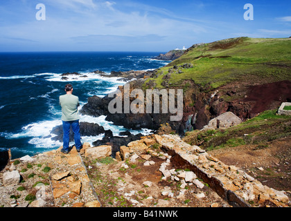 Man looking out to sea at Levant tin mine on the Cornish coast. Stock Photo