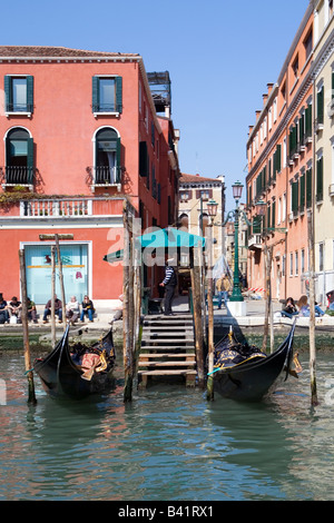 Gondolier waiting with Gondalas Moored on the Grand Canal venice Italy Stock Photo