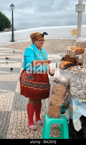 A woman  sells nuts and dried fruit at an open stall in Nazare, Portugal. Stock Photo