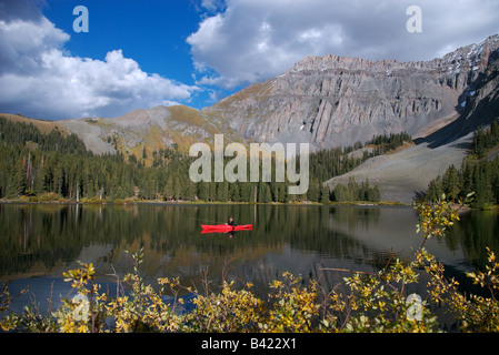 A sea kayaker fly fishing in an alpine lake high up in the san juan mountains near telluride, colorado at sunset in the fall Stock Photo