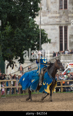 A galloping knight on horseback entertains the crowd during a jousting re-enactment at Lulworth Castle in Dorset England UK Stock Photo