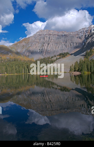 A sea kayaker fly fishing in an alpine lake high up in the san juan mountains near telluride, colorado at sunset in the fall Stock Photo