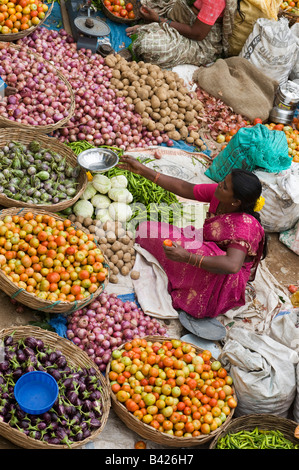 Indian woman selling vegetables at a local india market in the town of Puttaparthi, Andhra Pradesh, India Stock Photo