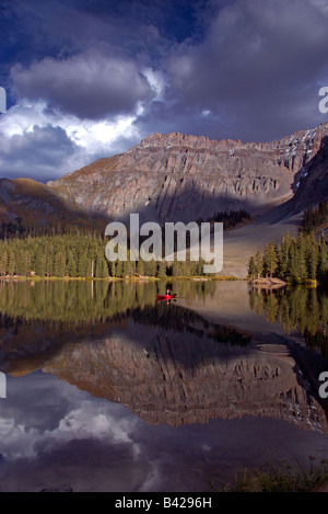 A sea kayaker fly fishing in an alpine lake high up in the san juan mountains near telluride, colorado at sunset in the fall Stock Photo