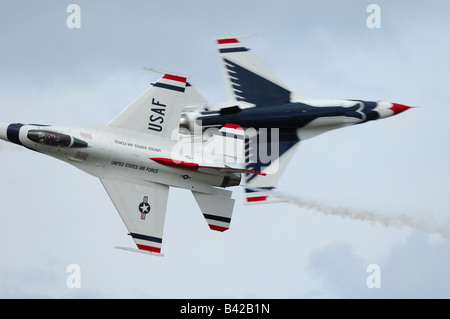 2 solos F-16 jet fighters passing each other - aerobatic team Thunderbirds in flight at Elmendorf Air Force Base Stock Photo