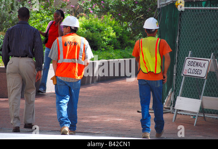 Two construction workers walking down the street Stock Photo