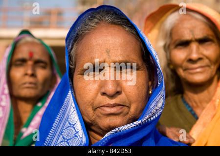 Three Hindu women wearing scarves over their heads stand on the Dasawamedh Ghat in the city of Varanasi, India. Stock Photo