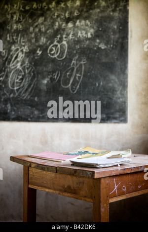 A much used chalkboard and desk in a Rwandan classroom. Stock Photo