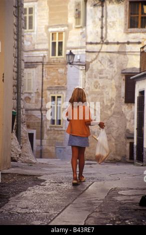 A girl early in the morning with fresh bread in the town of Lovran near Opatija, Istrian peninsula, Croatia Stock Photo