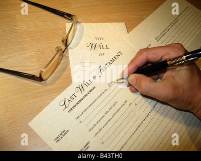 Man's hand writing a Last Will and Testament using a blank standard form Stock Photo