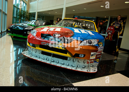 Kyle Busch's m&m Toyota Camry NASCAR race cars with sponsor decals on display at Joe Gibbs Racing showroom Stock Photo