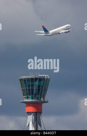 Delta Air Lines Boeing 767-332/ER taking off in the background of London Heathrow control tower. Stock Photo