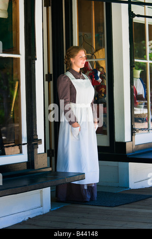 Young woman standing in store doorway Stock Photo