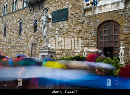 Tourists with umbrellas milling around the statue of David in Piazza della signoria, Florence, Italy Stock Photo