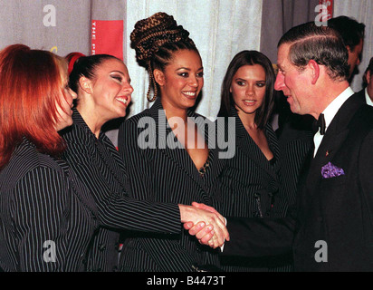 Spice Girls Geri Halliwell Mel B and Victoria Adams look on as Mel C shakes hands with Prince Charles at premiere Stock Photo