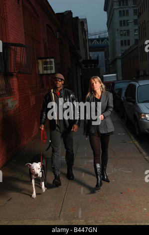 Young Interracial couple walking dog. Brooklyn, NY. Stock Photo