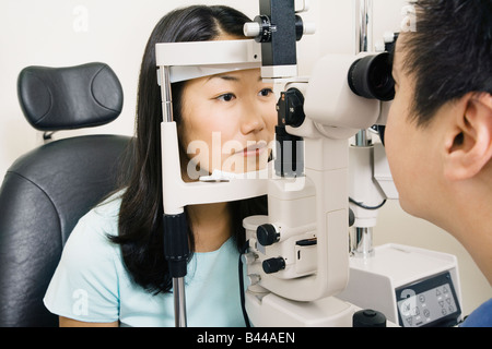 Asian male optometrist examining patient Stock Photo