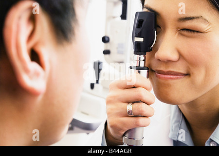Asian female optometrist examining patient Stock Photo