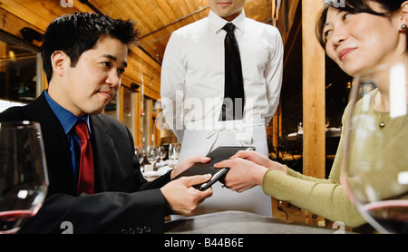 Asian couple fighting over restaurant bill Stock Photo