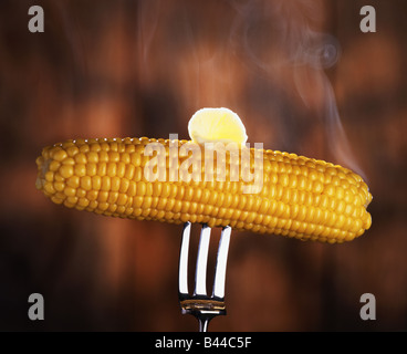 Corn on the cob with melting butter on a fork Stock Photo