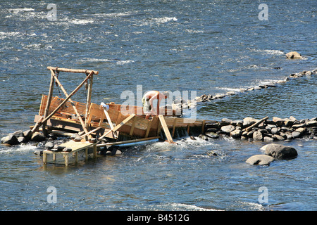 An eel weir on the Delaware River between Pennsylvania An eel man is working on the weir in the middle of the river. Stock Photo