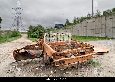 Taken without owners consent burnt out car underneath the M60 motorway in Greater Manchester. Stock Photo