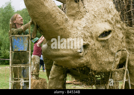 Making a rhino sculpture out of wooden branches, mud and straw in the Greenfield area. Glastonbury Music Festival 2003 Stock Photo