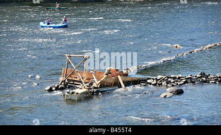 An eel weir on the Delaware River between Pennsylvania An eel man is working on the weir in the middle of the river. Stock Photo