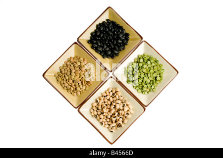 Four plates with lentils, black beans, black eyed peas, split peas Stock Photo