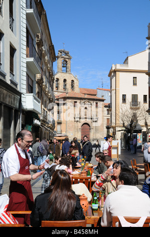 Street pavement café with waiter taking order on Rua Mayor Salamanca Spain with Church San Martin in background Stock Photo