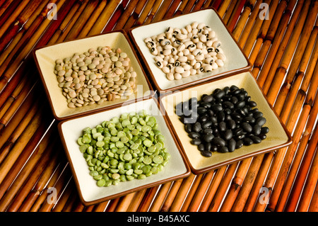 four dishes of lentils, peas, beans, black eyed peas on bamboo Stock Photo
