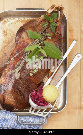 Roasted goose in roasting tray with dumpling and red cabbage, elevated view Stock Photo