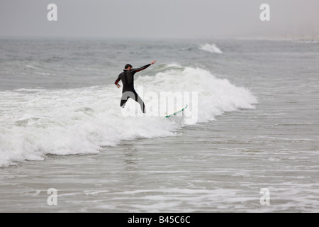 Surfing waves of Far Rockaway Beach during very foggy day New York USA Stock Photo