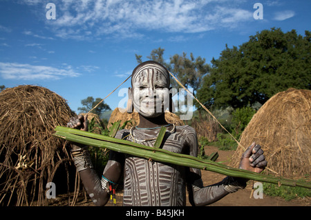 Young painted boy from the Mursi tribe holding a gun made out of leaves, Mago National Park, Southern Ethiopia, Africa Stock Photo