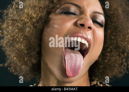 Mixed Race woman sticking out tongue Stock Photo
