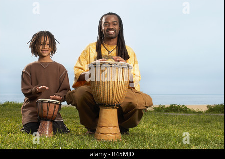 African father and son playing drums Stock Photo