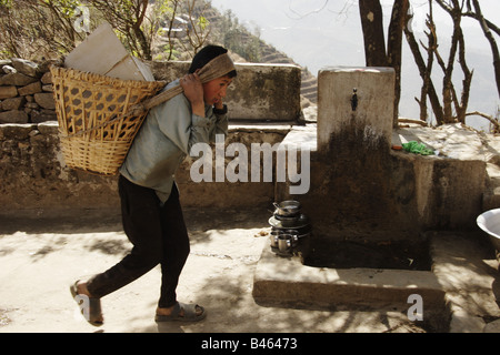 Young boy carrying supplies in the hills of Nepal Stock Photo